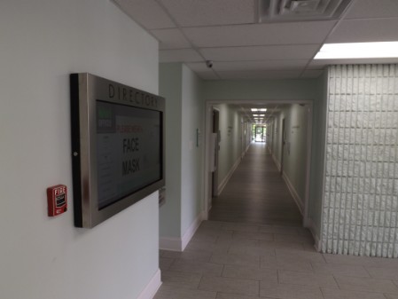 a hallway with a tv mounted on the wall.