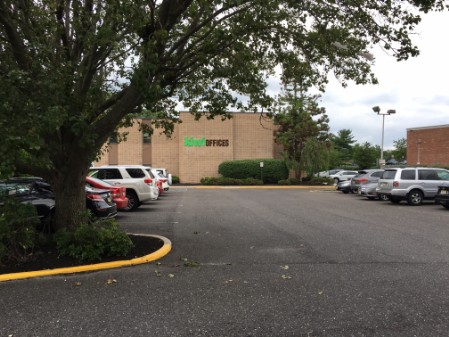 a parking lot with parked cars and trees.	